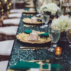 decorative table setting for event with gold and green accents